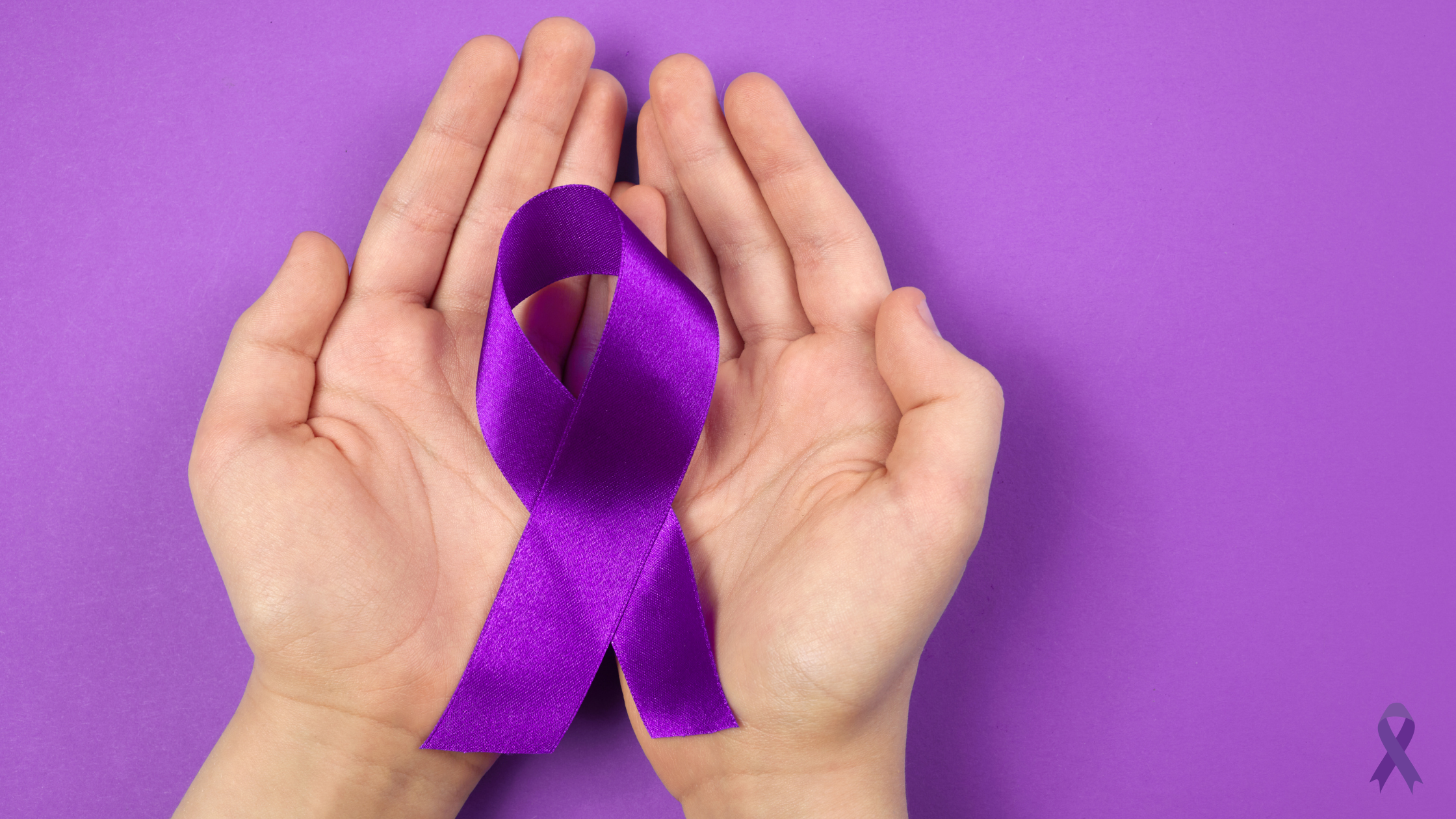 Hands holding a purple ribbon, symbolizing Alzheimer's awareness and support.